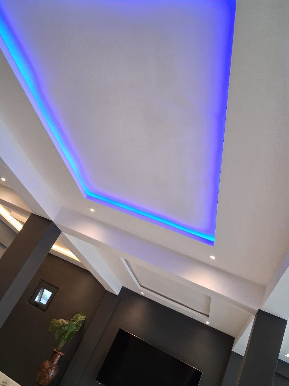 LED cove lighting set into a POP ceiling detail above a living room TV wall