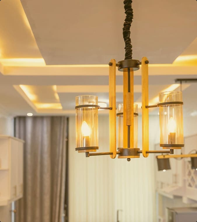 Pendant chandelier under a stepped POP tray ceiling with cove lighting