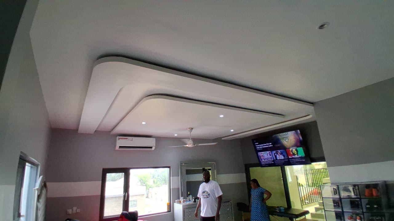 Salon in Keta with a layered curved POP ceiling, recessed downlights, and banded two-tone painted walls